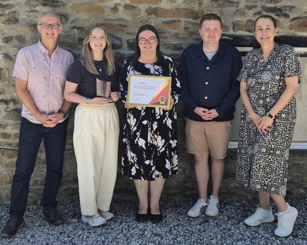 five members of the NBF team standing outside proudly holding their winning trophy and certificate