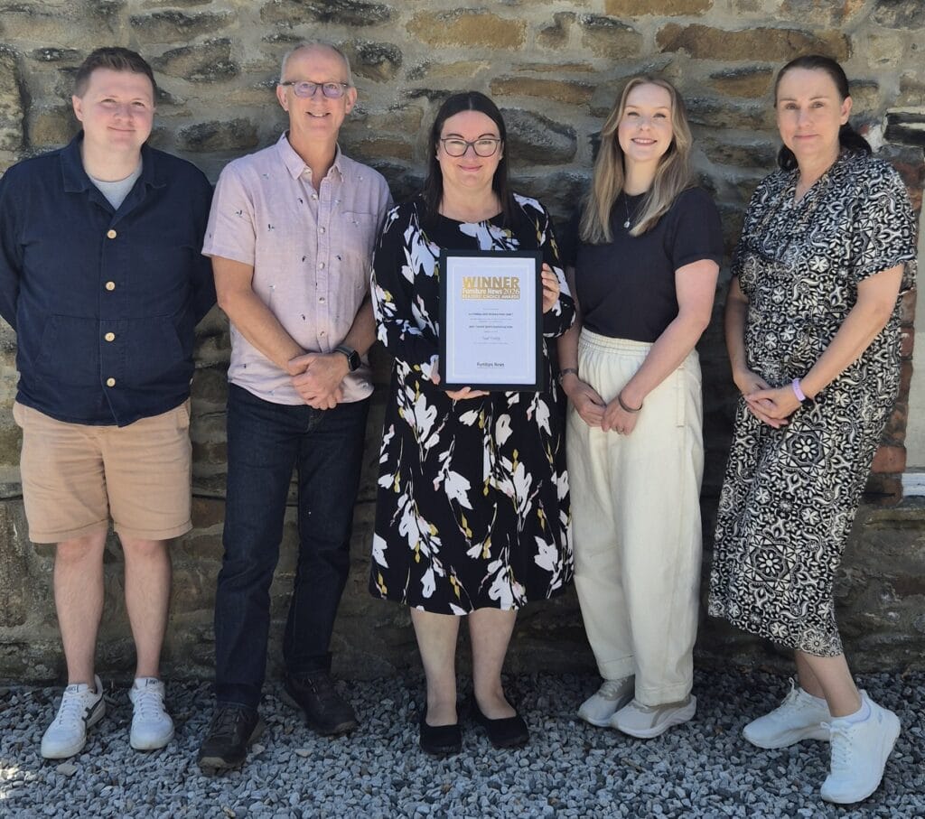 five members of the NBF team standing outside proudly holding their winning trophy and certificate
